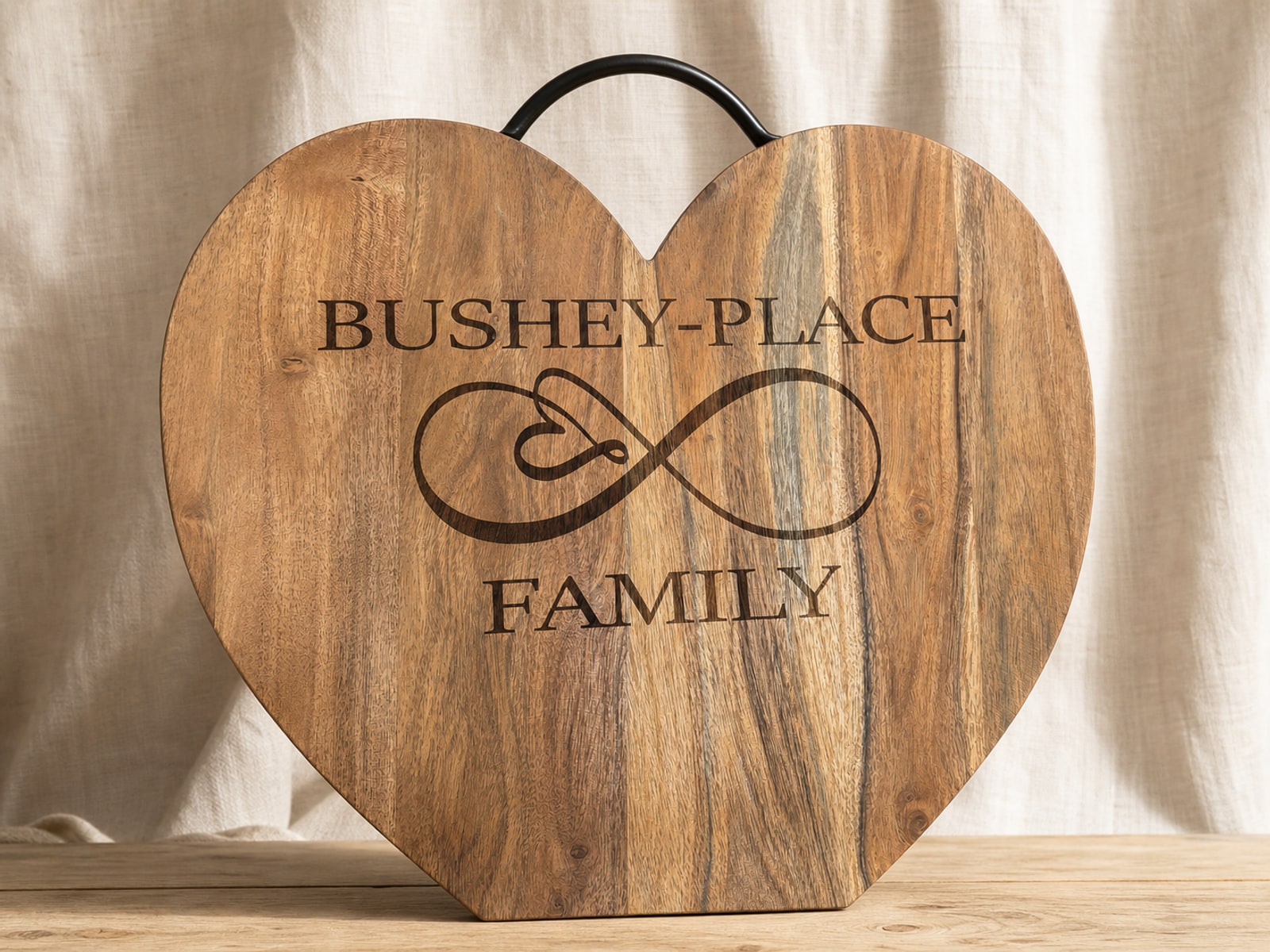Heart-shaped wooden family board with a personalized name and infinity-heart engraving